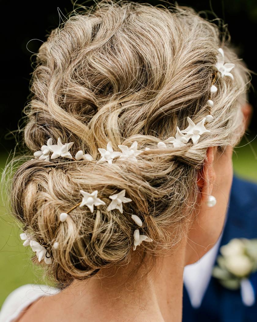 Blonde Hochsteckfrisur mit Blüten- und Perlennadeln