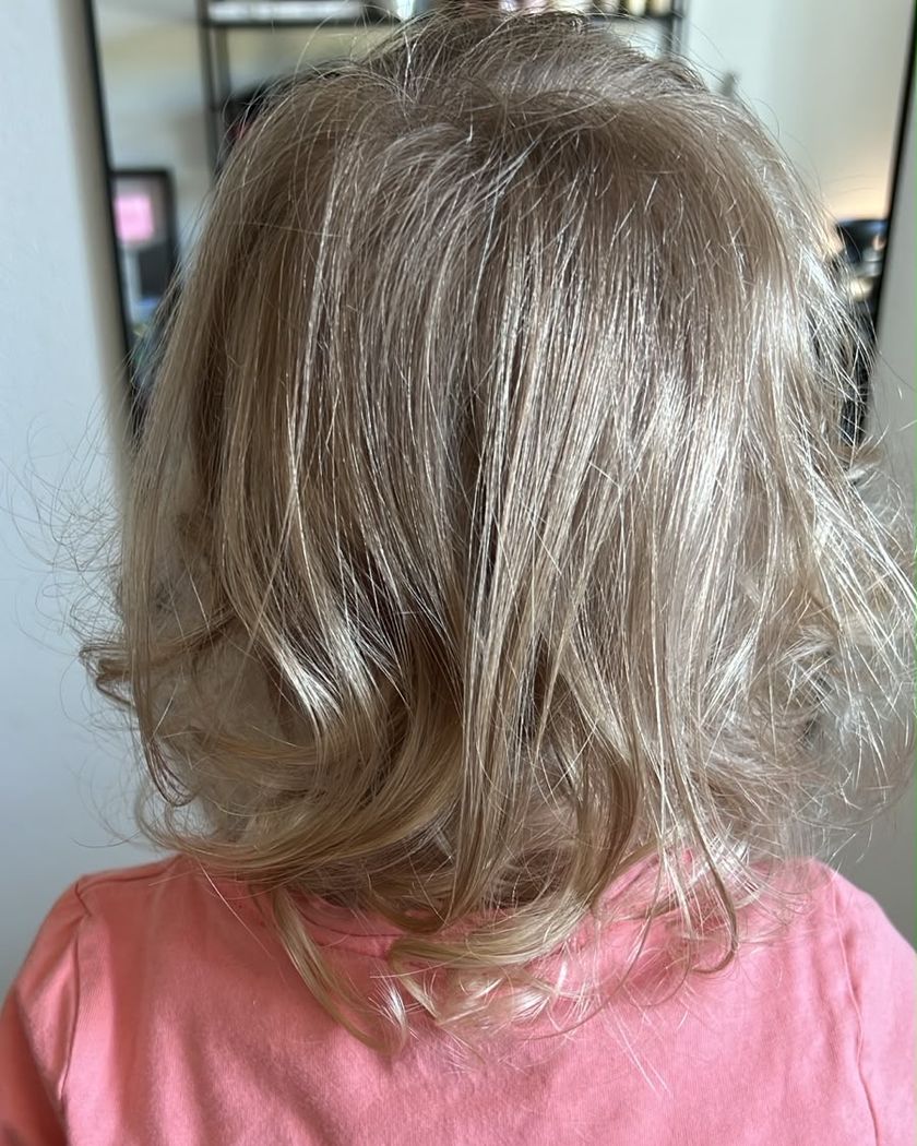 Kinderhaarschnitt: blondes, leicht gewelltes Haar von hinten